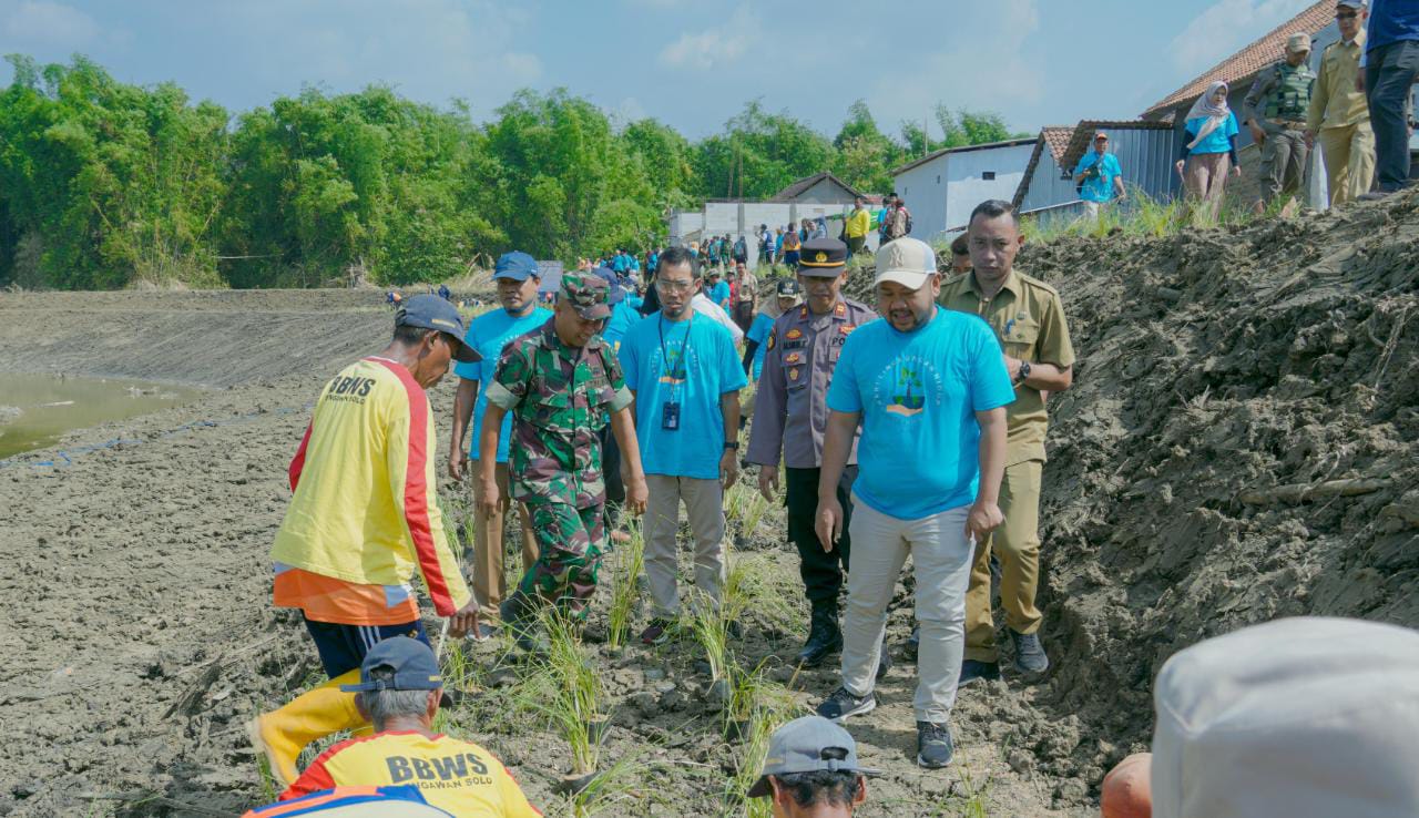 Ket: Gus Yani (Bupati Gresik) menanam rumput vetiver di sempadan sungai kali Lamong bersama warga. (Sumber: Istimewa)